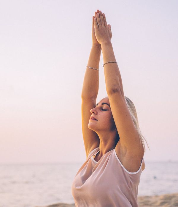 Person stretching outdoors at sunrise feeling energized.