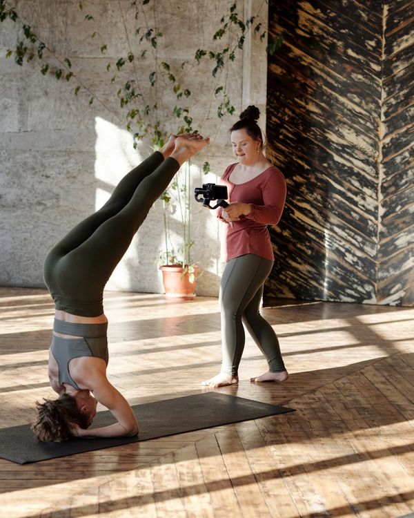 Woman in a fluid yoga pose in a dark room with pistachio green light.
